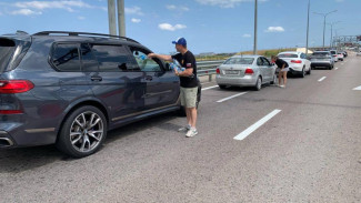 У Крымского моста со стороны Керчи раздают бутилированную воду   