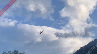 Вертолёт забирает воду с моря для тушения пожара в Алуште 